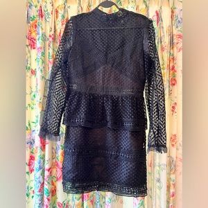 Black crochet mini dress, long sleeve, with high collar.